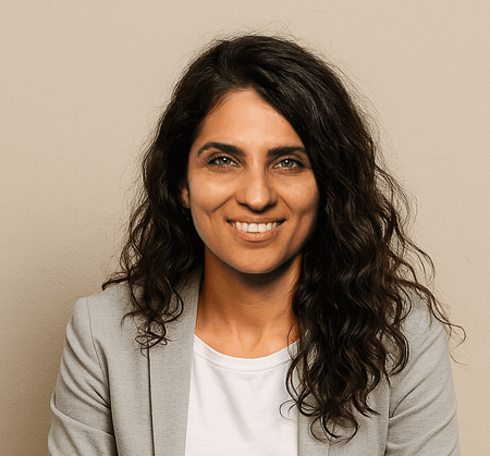 Headshot of Ghazaleh Afrahi, with dark curly hair, minimalist attire, and a smile.